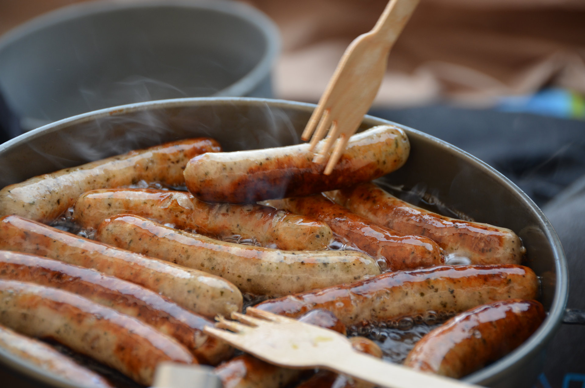 Würstchen brutzeln in der Pfanne von einem Trangia Kochset