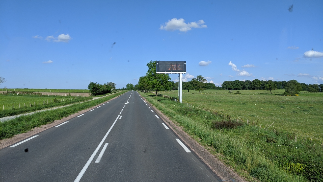 Eine leere Landstrasse in Frankreich mit einer Covid 19 Strassen Anzeige