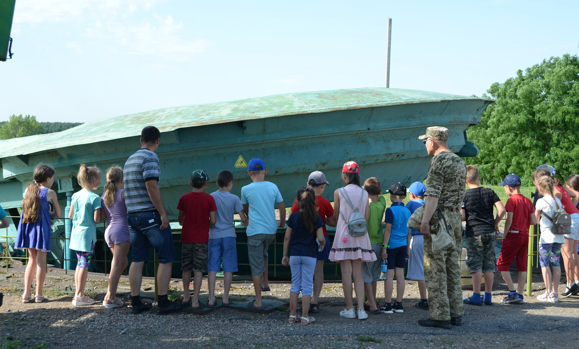Ein Trupp Schulkinder steht vor der Siloabdeckung vom Raketenmuseum Pobuzke