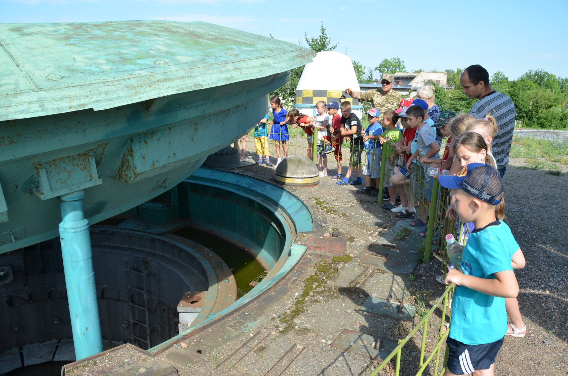 Besuchergruppe steht um  geöffnete Abdeckung vom Atomraketensilo herum 