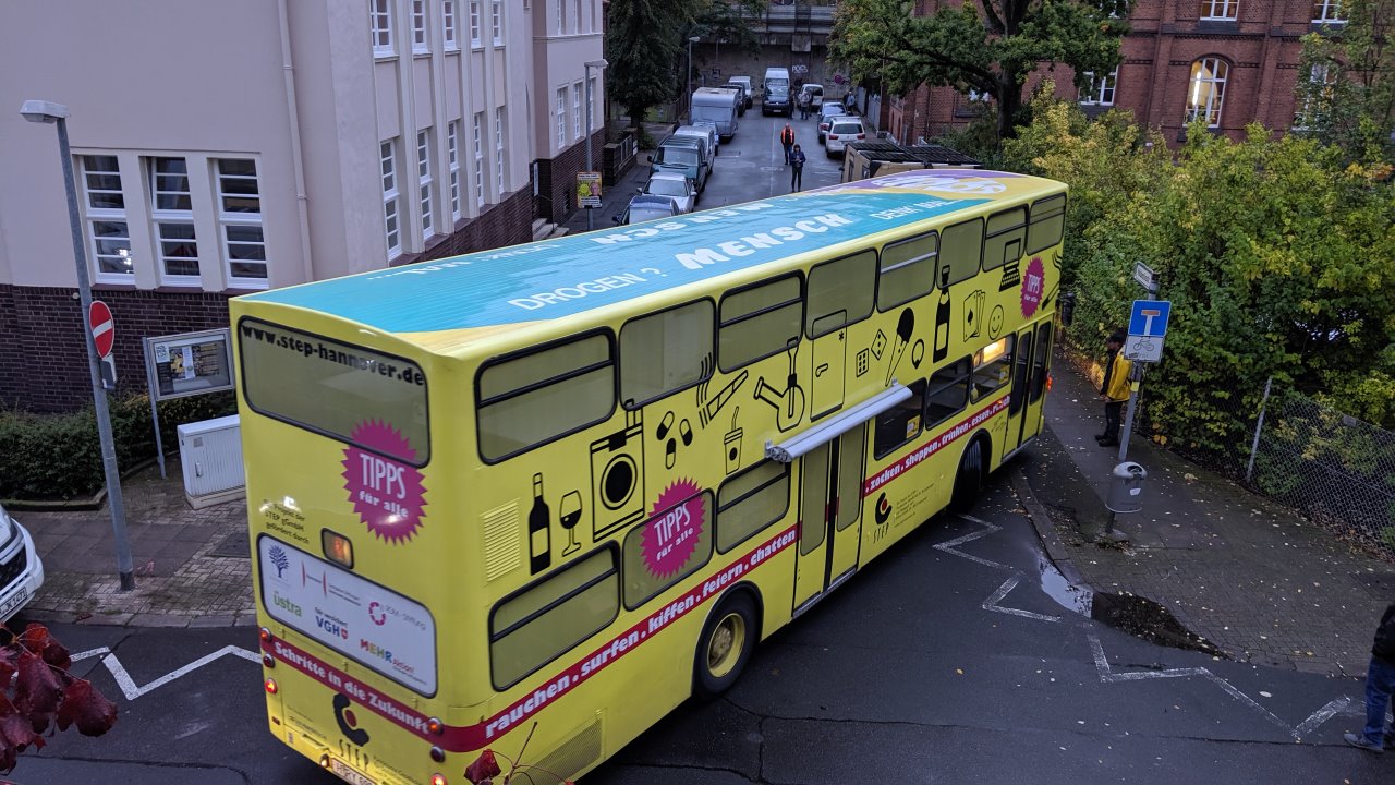 Ein gelber Doppeldecker Bus biegt in eine sehr enge Sackgasse ein