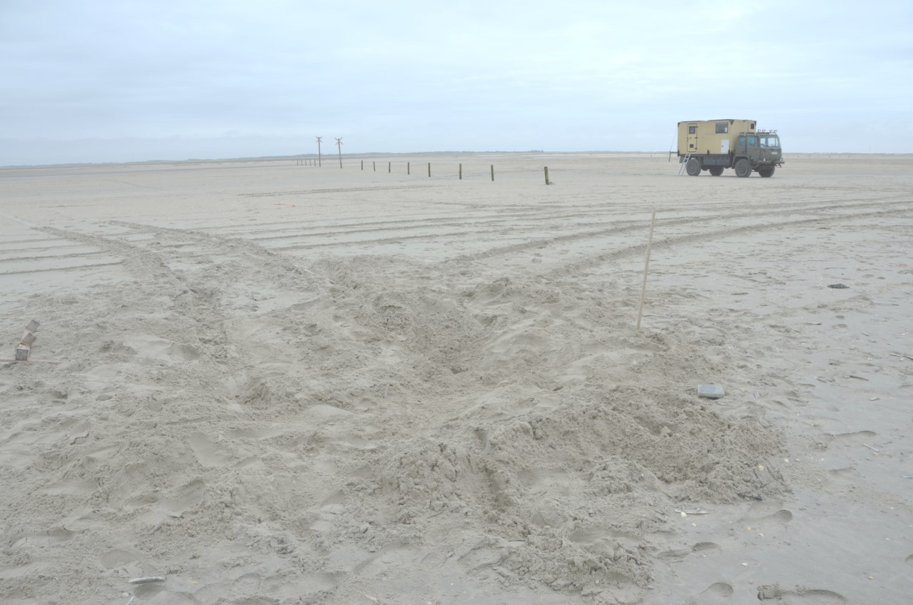 Spuren am Strand von einem Fahrzeug, was sich festgefahren hatte. 