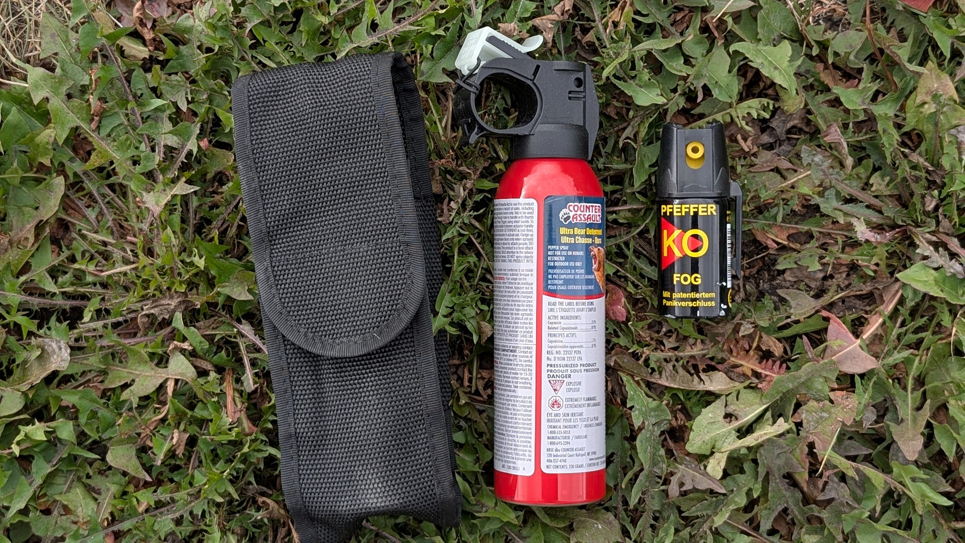 Eine rote Flasche Bärenspray neben einer kleinen Flasche Pfeffer Spray. 