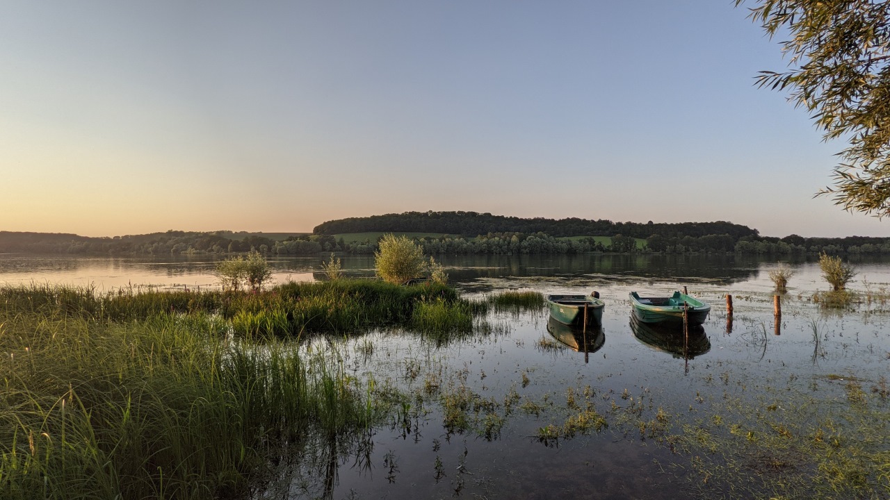 der Lac de la Liez bei Langres am Abend mit zwei kleinen Ruderbooten. 