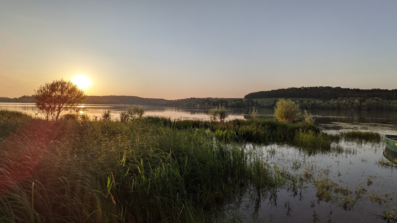 Sonnenuntergang am Lac de la Liez bei Langres. Die Abendsonne scheint auf die Uferböschung. 