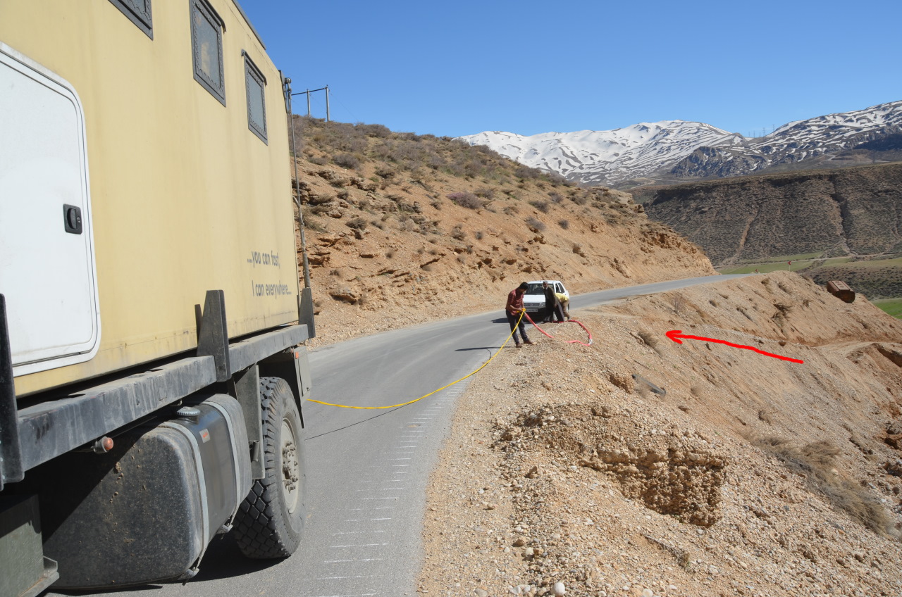 In iranischer Saipa wurde mit einem gelben Seil von einer abschüssigen Strasse zurück auf die Hauptstrasse gezogen. 