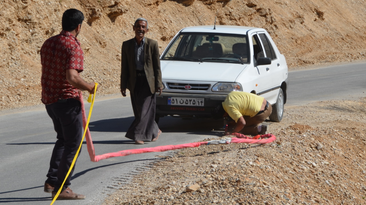 Drei Menschen vor einem weissen Saipa aus dem Iran 