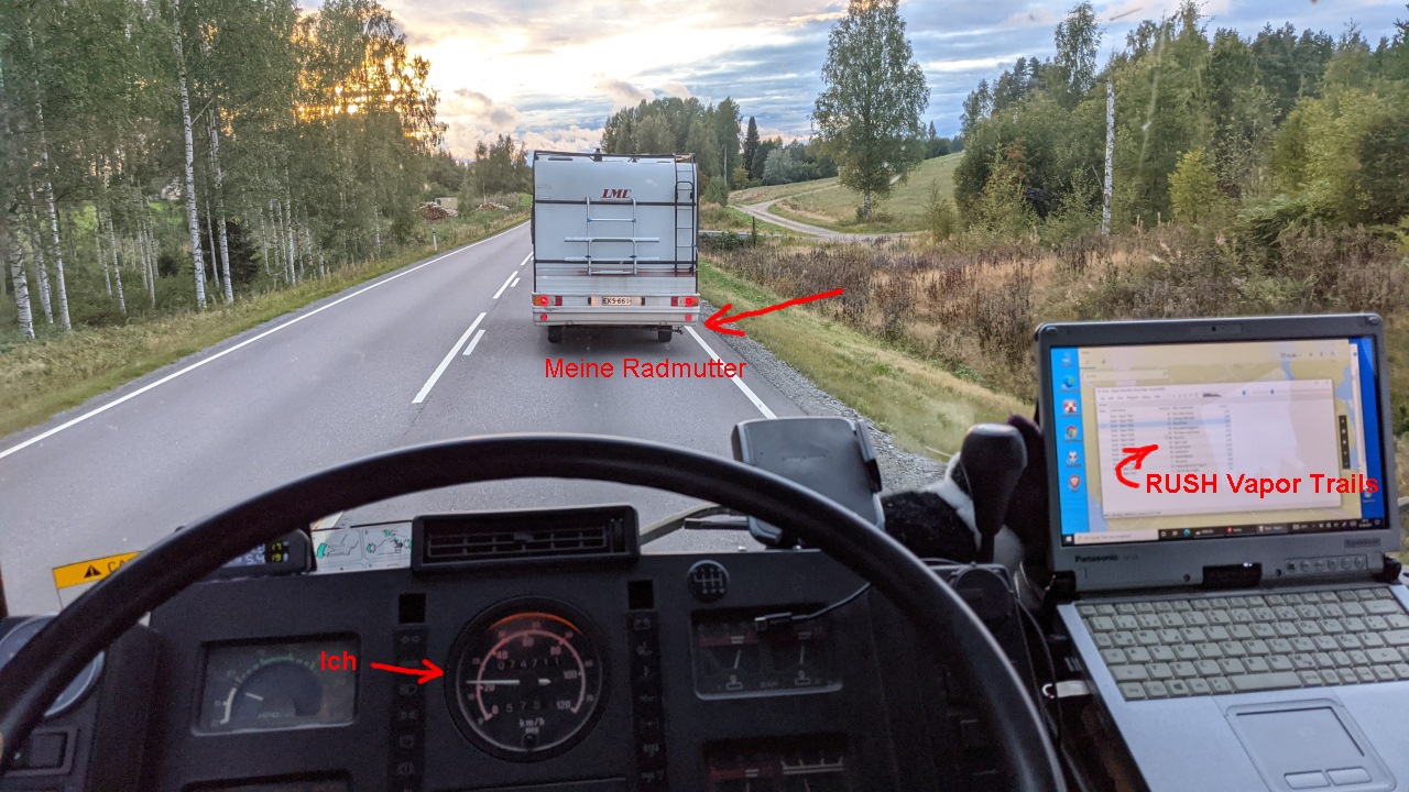 Ein Campingwagen fährt langsam durch Finnland, vom LKW Cockpit aus gesehen 