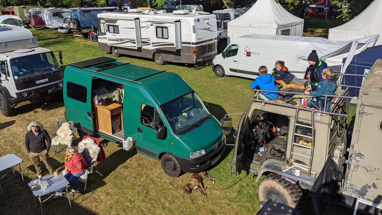 Überblick über die OTTO Touristik Messe Ohrdruf mit unterschiedlichen Fahrzeugen. Vier Kinder haben es sich auf einem DAF T244 gemütlich gemacht. 