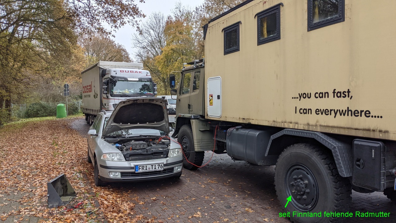 Ein silbernes Auto mit geöffneter Motorhaube erhält Starthilfe vom DAF T244