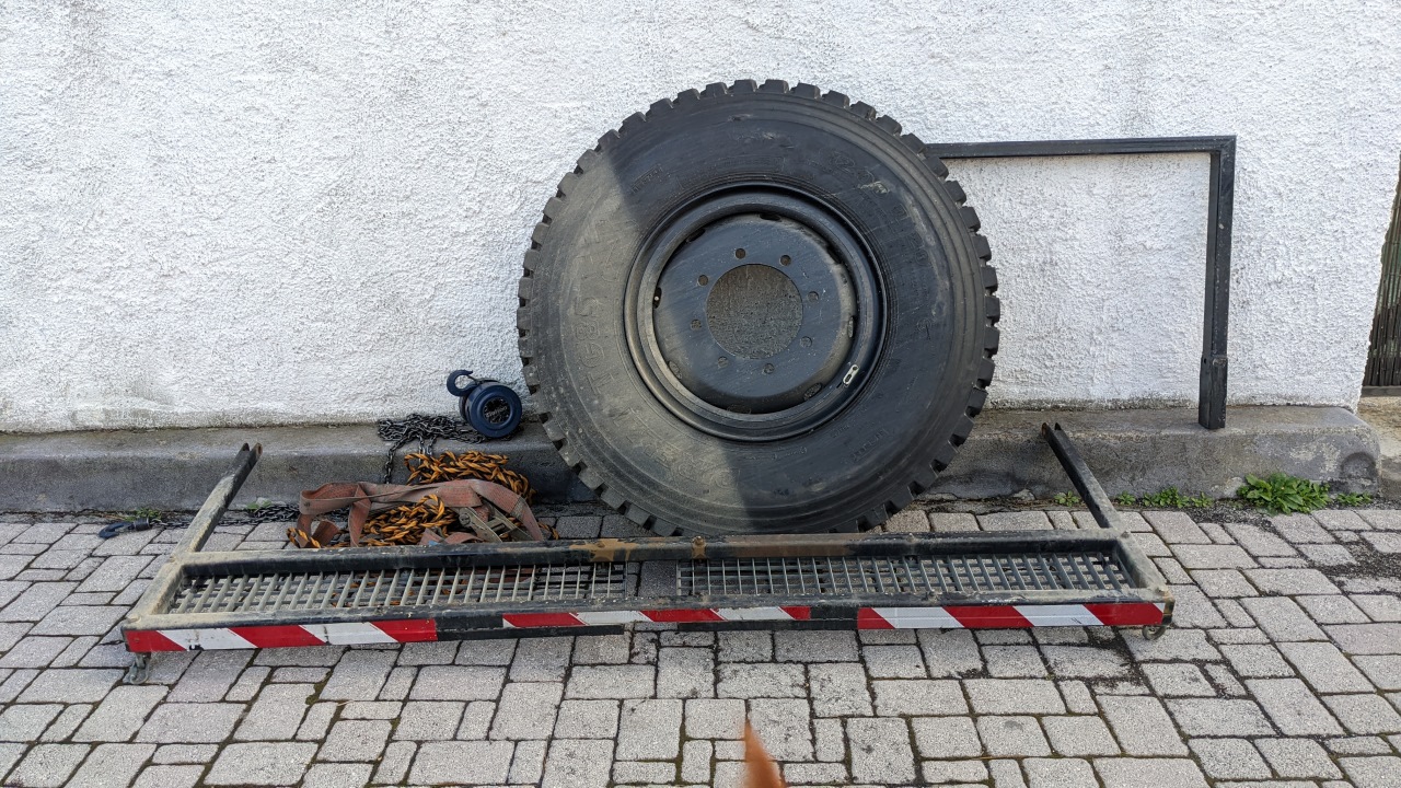 Ein abmontierter 12.00 Ersatzreifen Reifen und die abgebaute hintere Gangway vom LKW. 