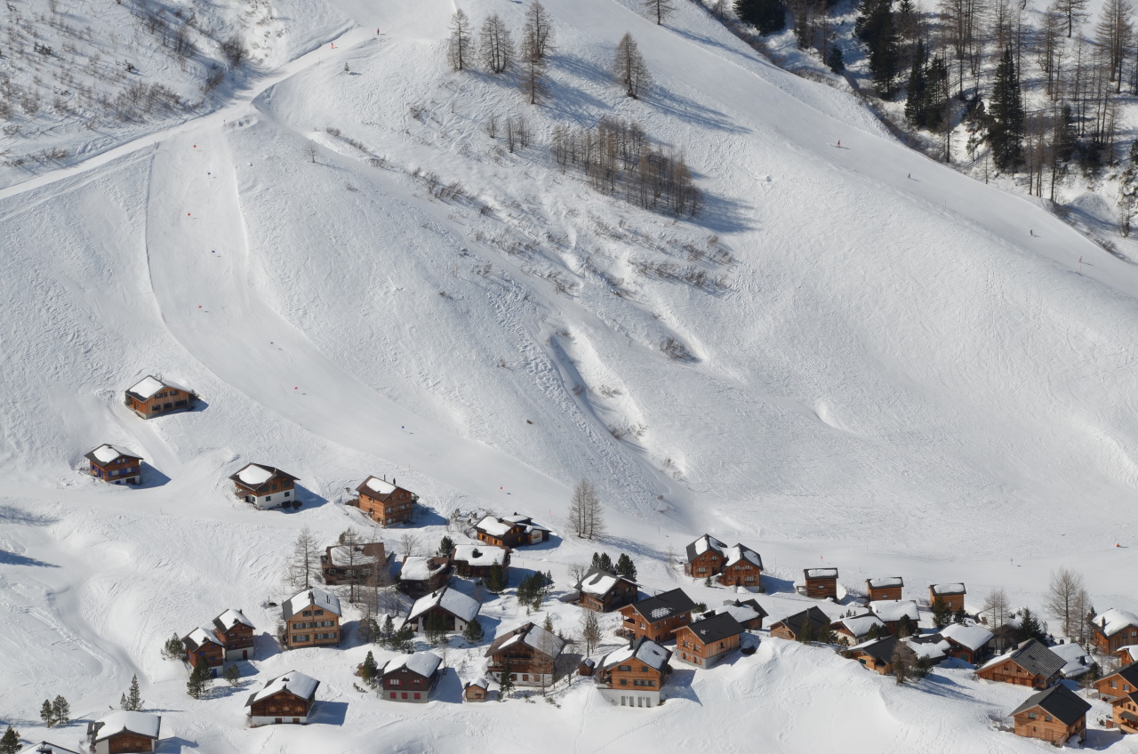 Block von schräg oben auf Einfamilien Häuser mit schneebedeckten Dächern in einer weissen Schnee Landschaft. 