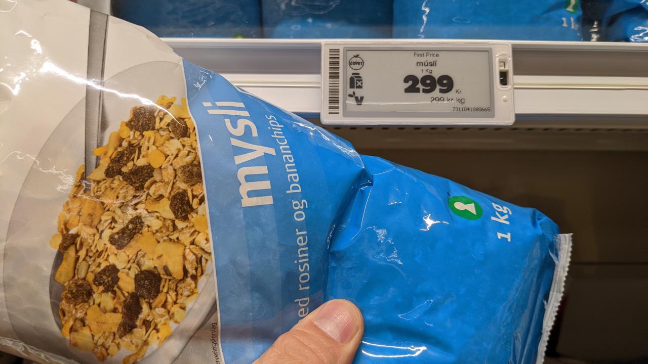 Eine Tüte Müsli mit Rosinen und bananenchips, in Hintergrund zeigt das Preisschild 299 Kronen