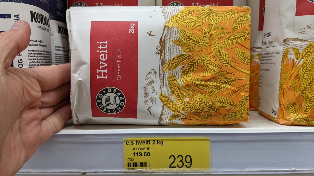 Eine Papiertüte mit 2kg weissem Mehl und ein gelbes Preisschild mit 239 ISK