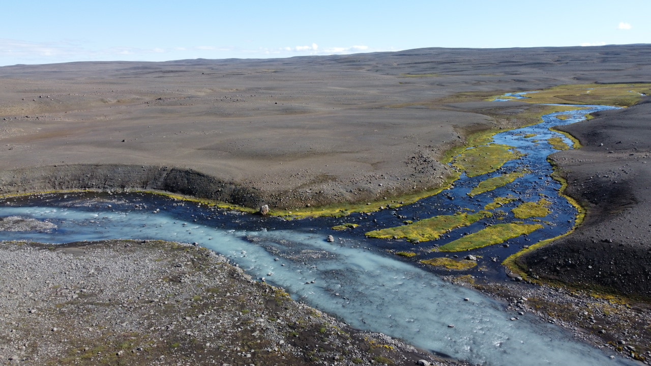 Milchfarbener Gletscher Zufluss in Island in karger, grauer Felslandschaft