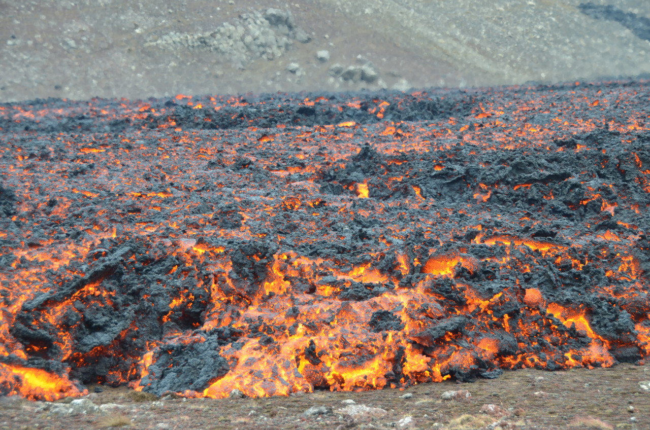 Rot glühende Lava mit schwarzen, erkalteten Schuppen