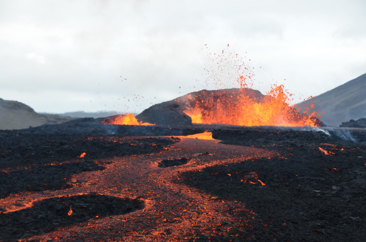 Rot glühende Lava aus dem Meradalir Vulkan Fagradalsfjall bahnt sich den Weg in ein kleines Tal