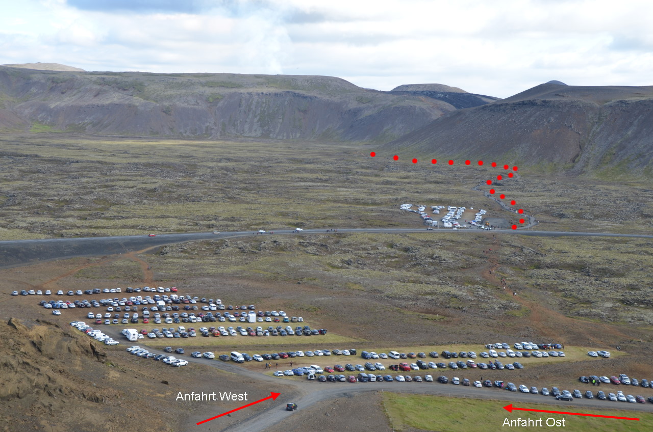 Parkplatz an der Strasse 427 mit Autos. Im Hintergrund ist der Wanderweg zum Vulkan Vulkanausbruch Fagradalsfjall mit roten Punkten markiert. 