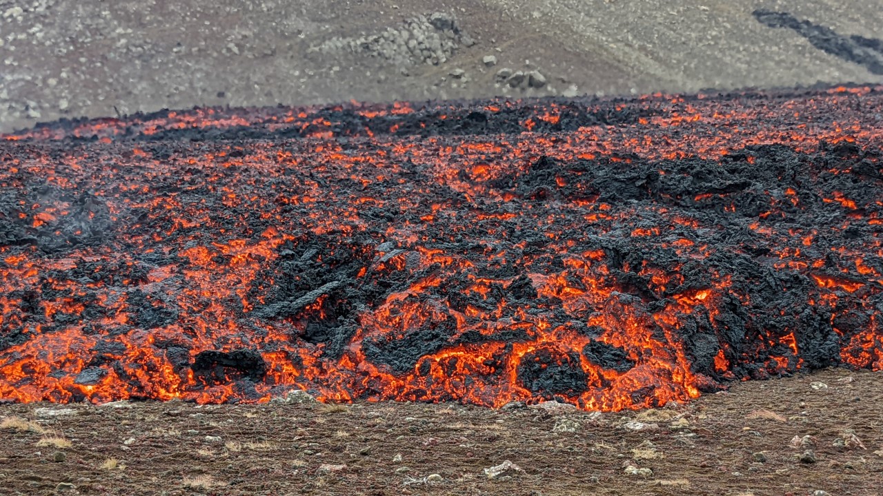 Eine rot glühende Lava Walze breitet sich auf der Erde aus und überrollt das Tal. 