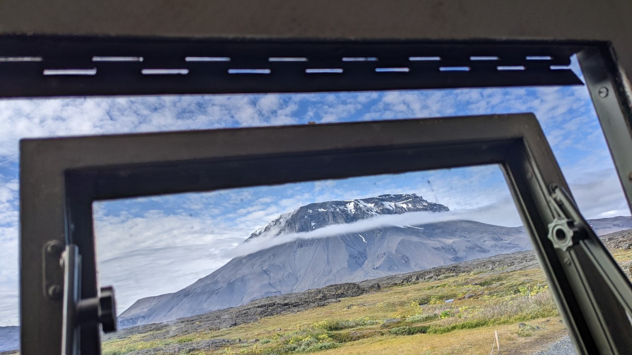 Rausgebrochenes Fenster, im Hintergrund der Herdubreid Island