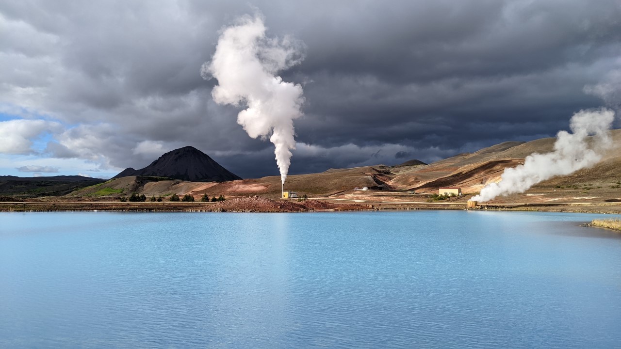 Eine weisse Dampswolke steigt über dem türkis farbenen See im Krafla Geothermalgebiet auf