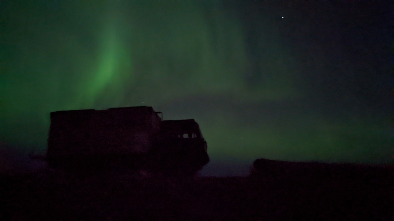 Grünes Autora Nordlicht in Island vor der dunklen Silhouette vom DAF T244
