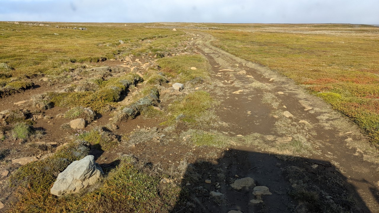 Ein stark zerfurchter und ausgewaschener Feldweg mit vielen Steine