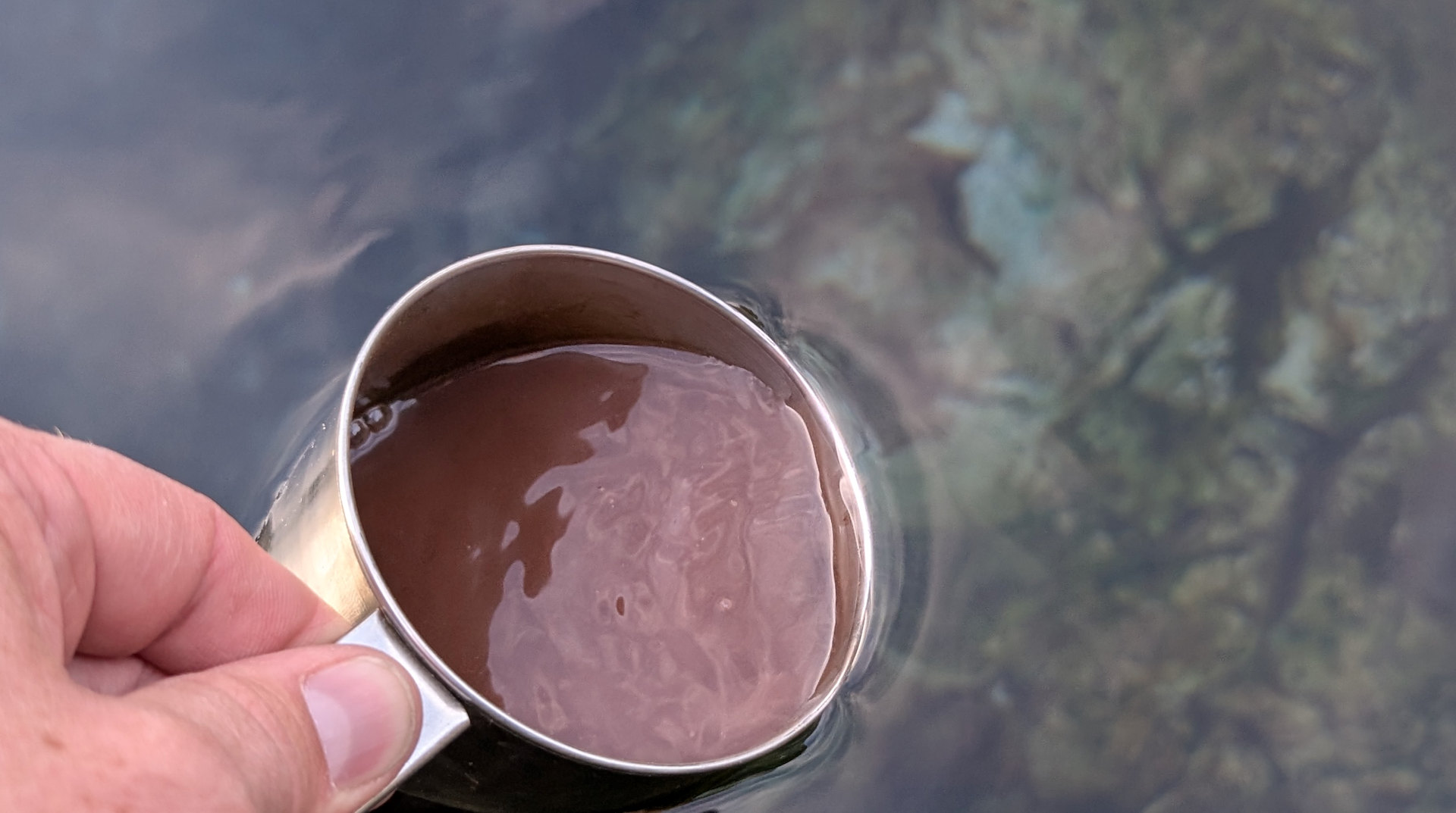 Tasse schöpft heisses Wasser um heisse Schokolade aus Instant Pulver zuzubreiten. 