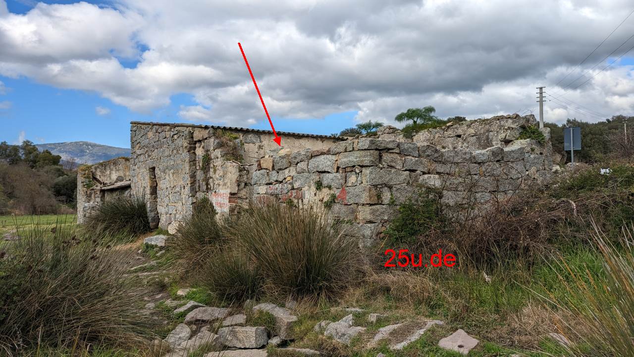 Ruine eines Stein Hauses, dem das Dach fehlt. Ein roter Pfeil zeigt ins Innere. Urheber ist 25u.de