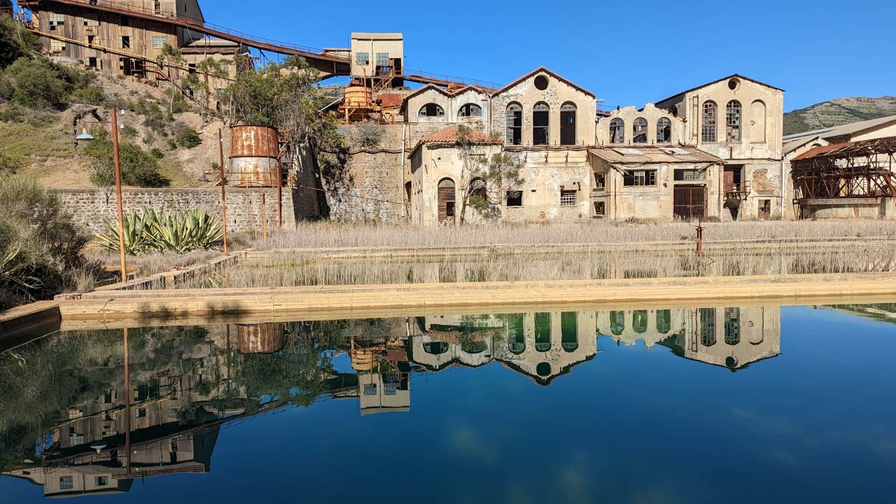 Industrieruinen Monteveccio Mine Sardinien spiegeln sich in blauem Wasser