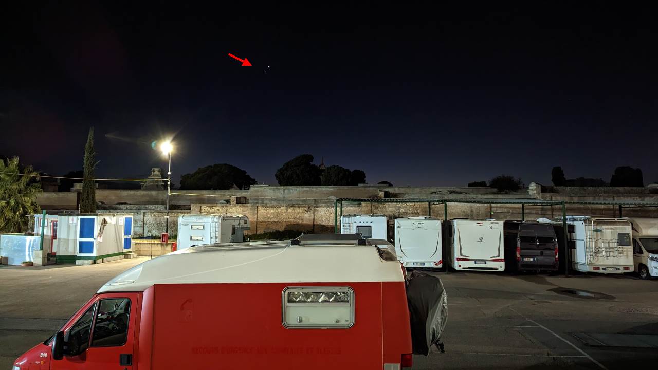 Camping Parkplatz bei Nacht, ein roter Pfeil zeigt auf die nah beianander stehenden Planeten Venus und Jupiter