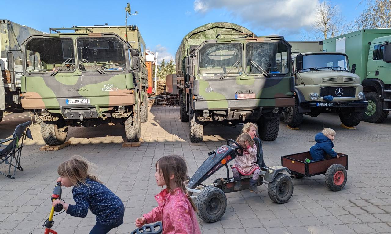Kinder spielen von zwei MAN Kat Militär LKW