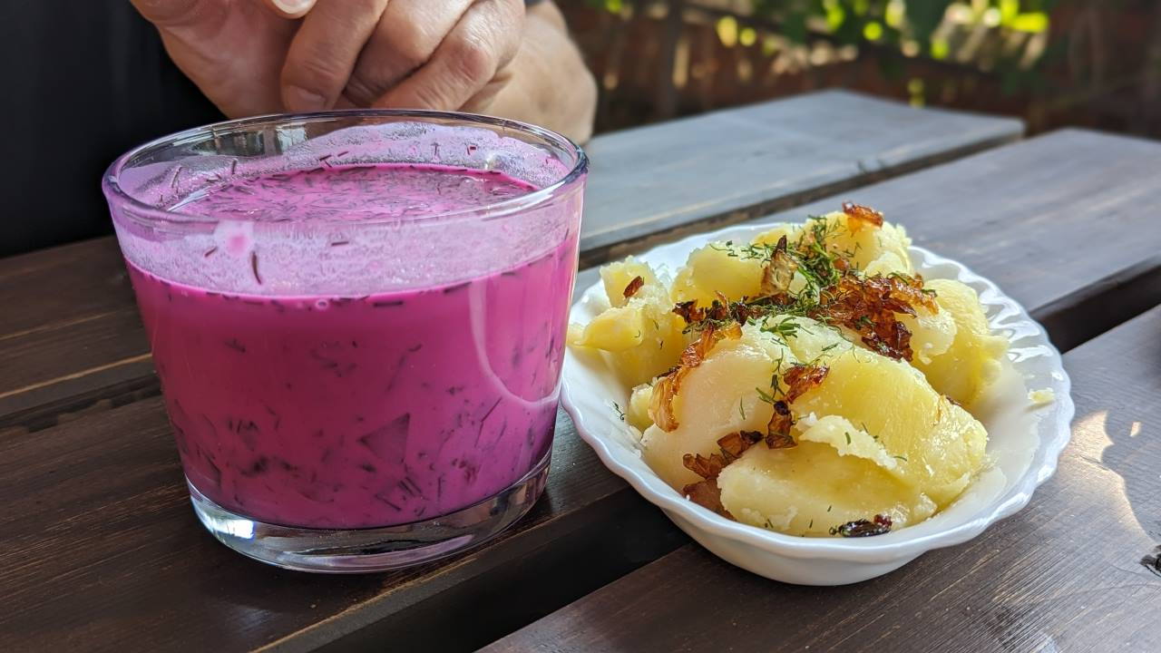 Pink farbene kalte Suppe aus Roter Beete, Gurke und Dill neben goldgelben gebratenen Kartoffeln mit gebratenen Zwiebeln