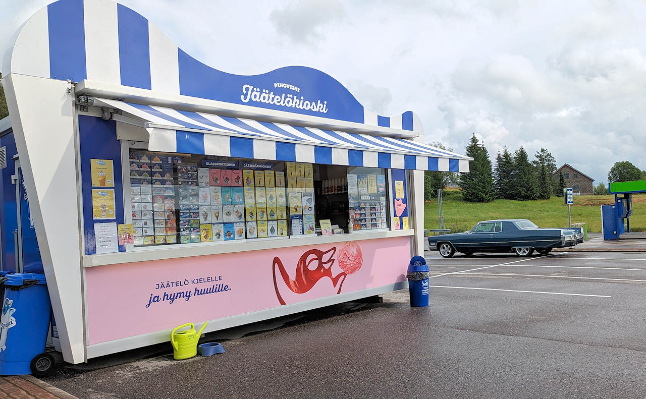 Eislanden in Finnland auf einem Parkplatz, im Hintergrund steht ein grüner US amerikanischer Oldtimer