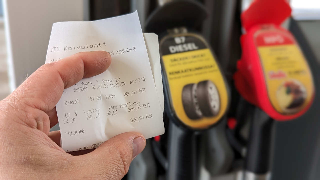 Eine Hand hält eine Quittung über getankten Diesel für 300€