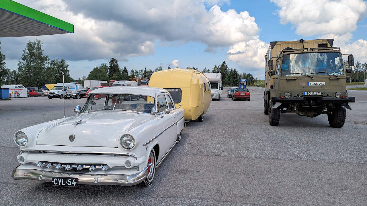 Ein Ford Crestline 1954 Strassen Kreuzer an einer Tankstelle mit DAF T244 Truck rechts daneben