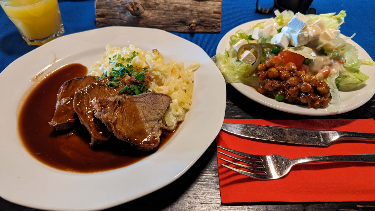 Ein Teller mit Fleisch, Salat und Kartoffeln als Mittagsmenü