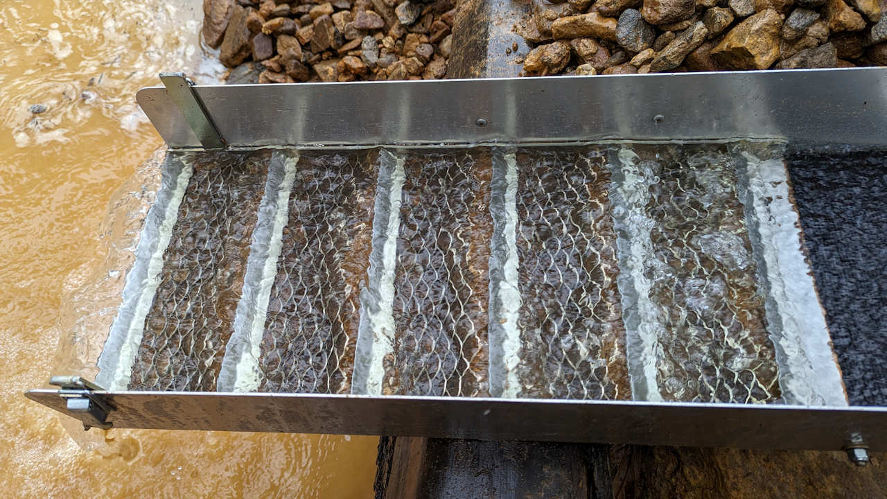 Eine Goldwaschrinne im Winkel von 10 Grad durch die Wasser fliesst