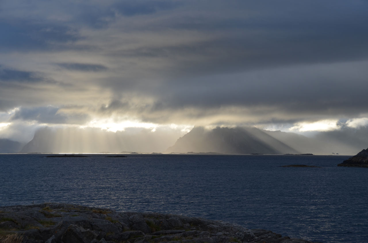 Schräg einfallenden Sonnenstrahlen mit Bergen und Meer