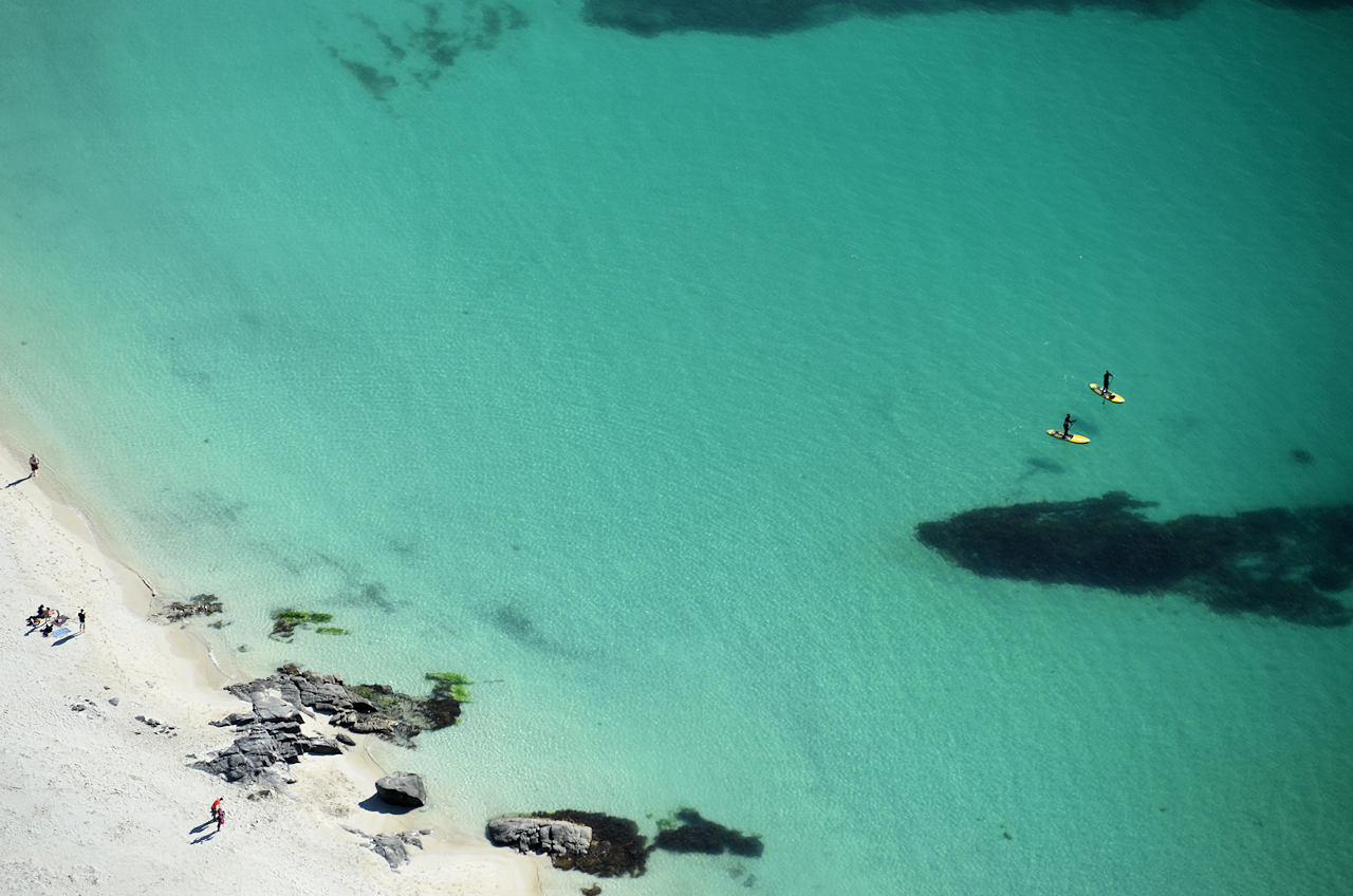 Luftbild vom Hauklandstranda mit ein paar badegästen am Strand und zwei Menschen auf einem Standup Paddle 