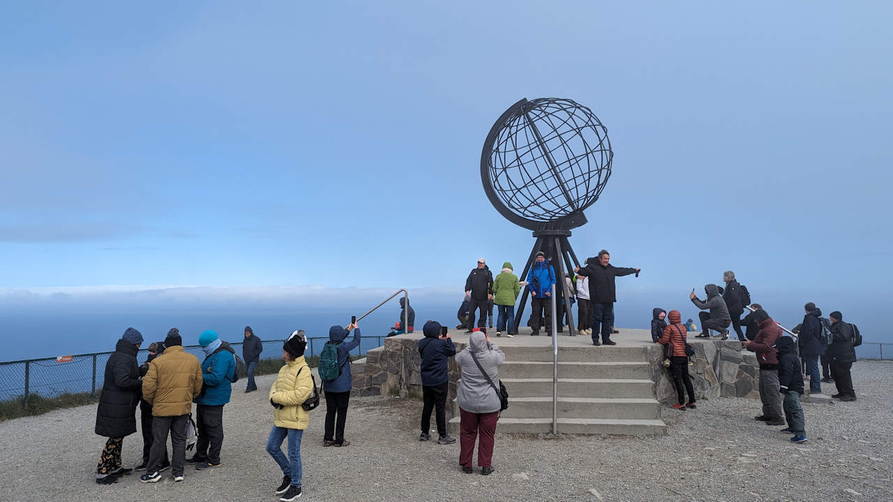 Nordkapp Kugel in Norwegen mit einer Gruppe Touristen
