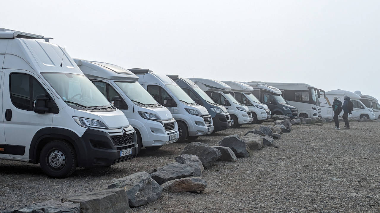 Auf dem Nordkapp Parkplatz stehen dicht gedrängt etwa 12 Campingfahrzeuge