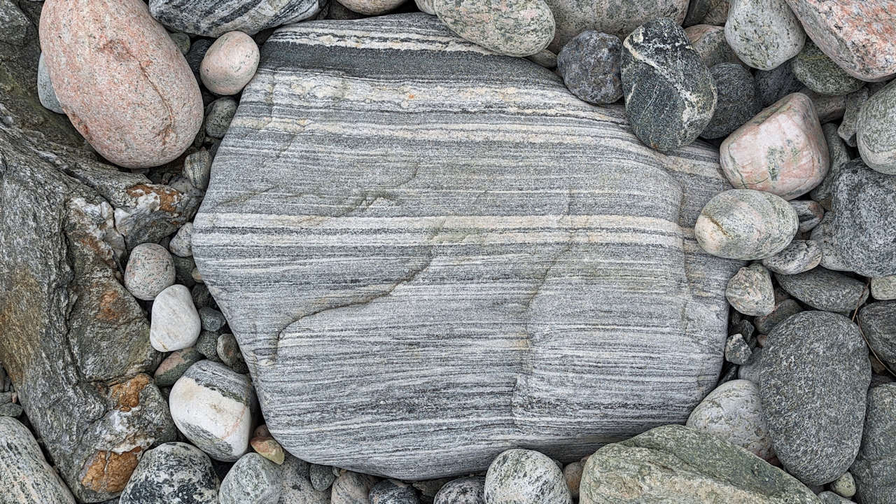 Markant weiss und grau gemusterter Stein am Strand von Grotfjord 