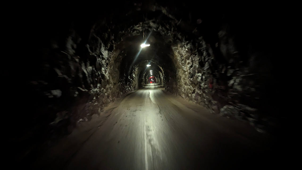 Fahrt durch einen dunklen, nur spärlich beleuchteten Tunnel in Norwegen