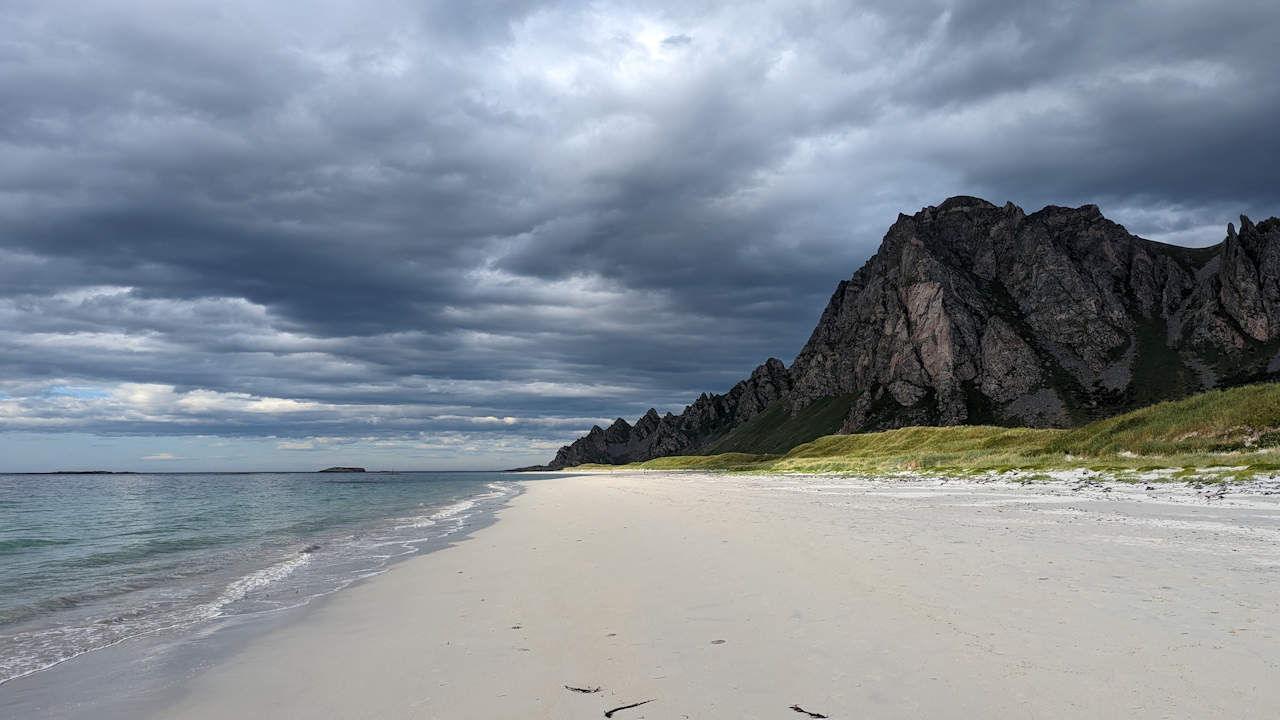 Strandabschnitt mit dunklen Wolken in Bleik, Norwegen