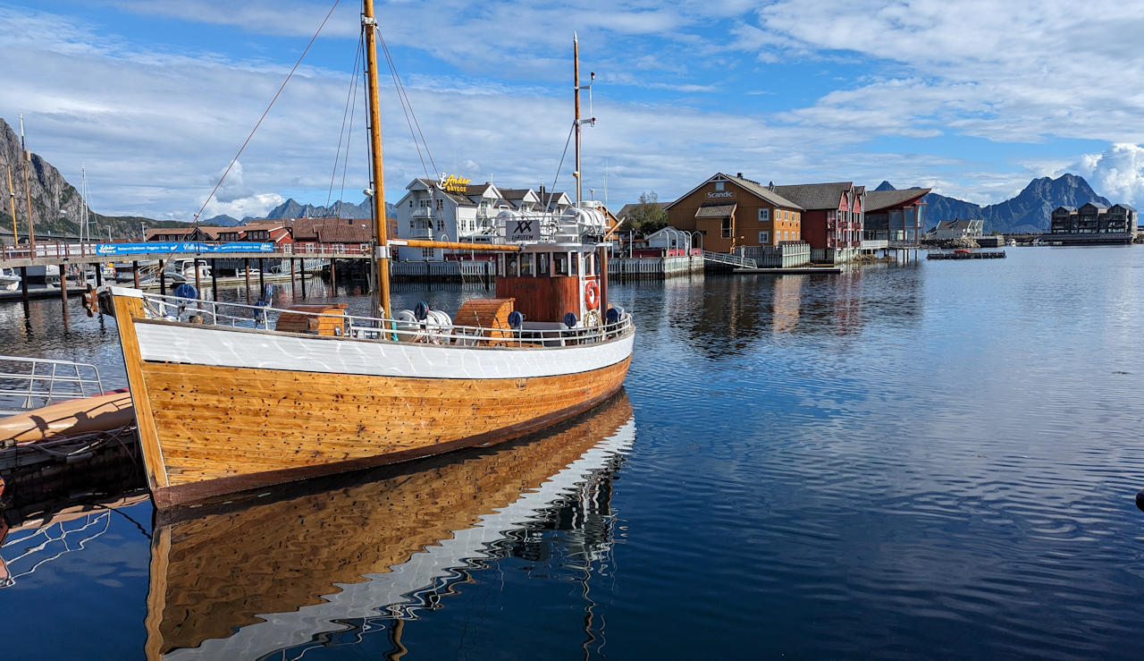 Neues Fischerboot mit hellem Holzrumpf schwimmt im Wasser von Svolvaer Lofoten Norwegen