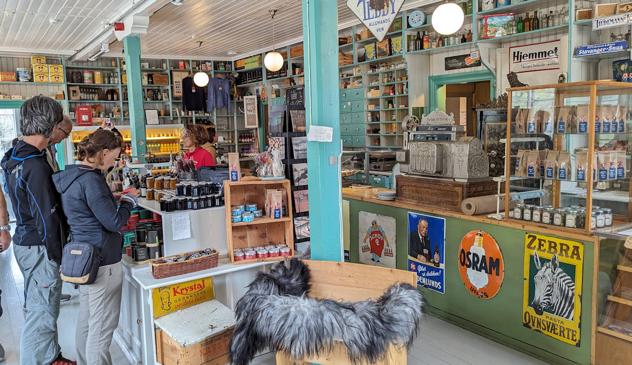 Besucher in einem als Kolonialwarenladen gestalteten Cafe in Nusfjord Lofoten. 