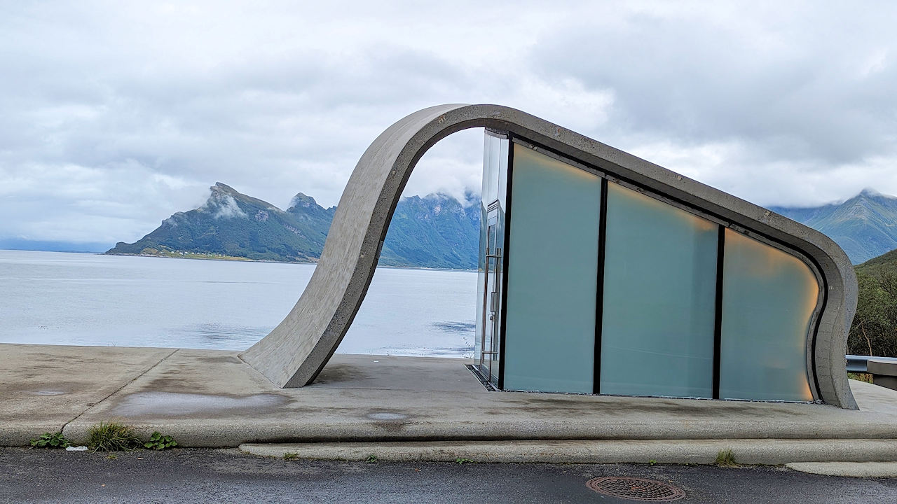 Modernes Klohaus mit geschwungenem Dach vor einem Fjord in Norwegen