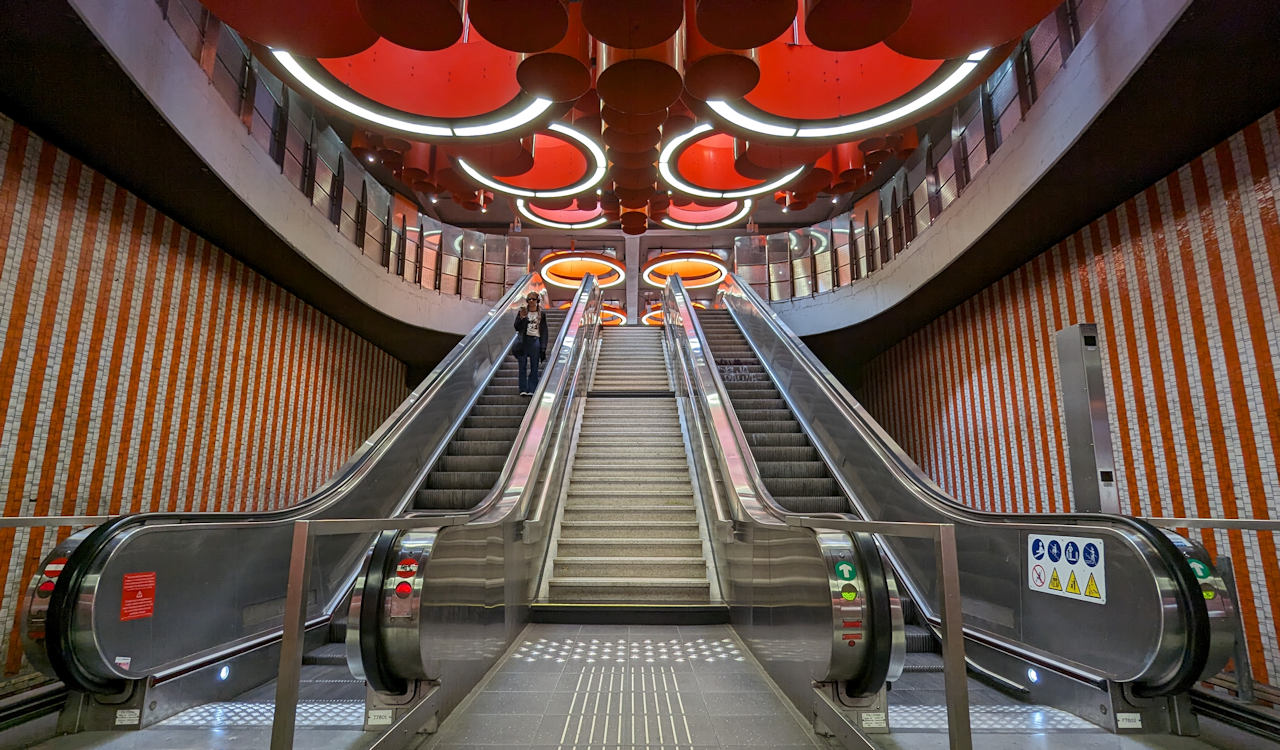 Rolltreppe der Metro Station Pannenhuis in Brüssel mit orangenen Deckenlichtern