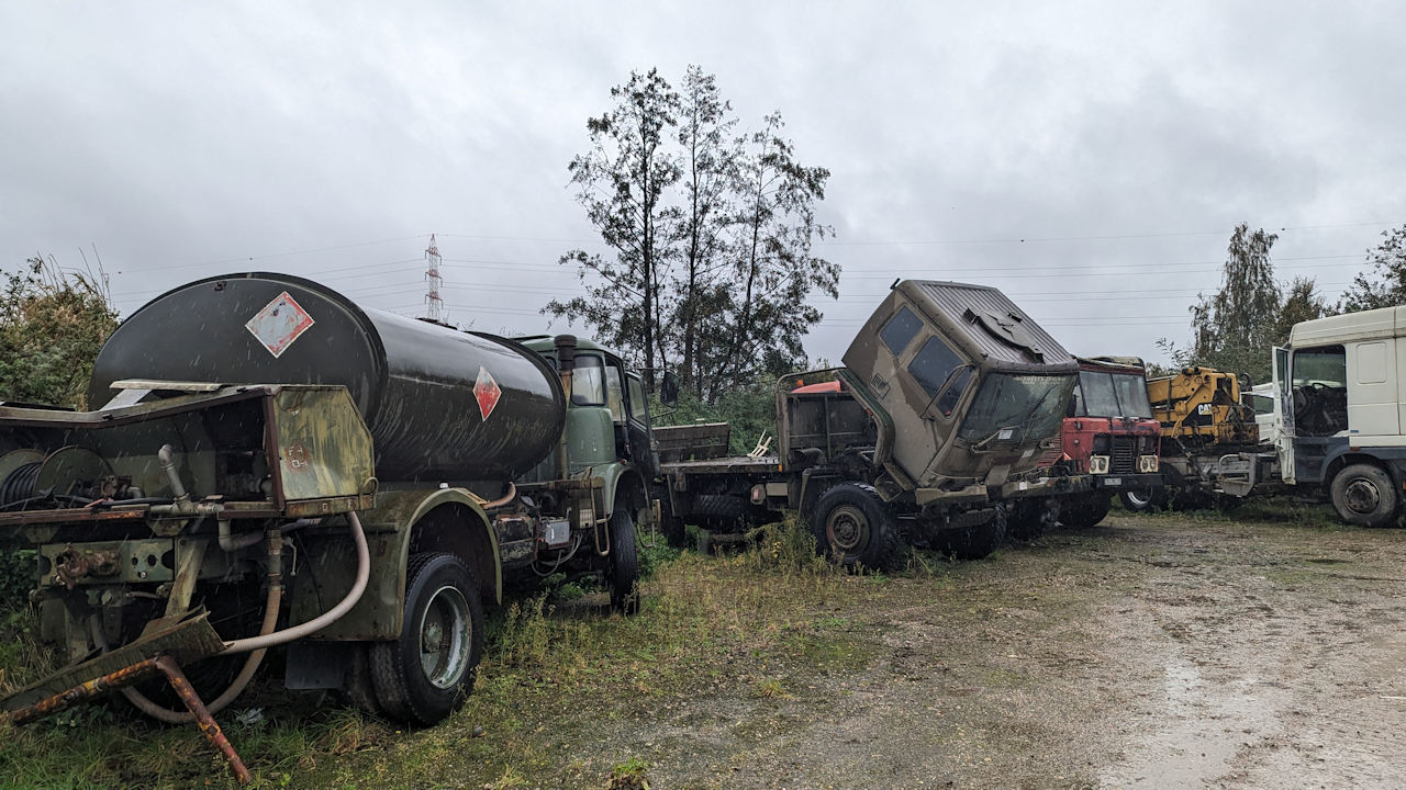 Autofriedhof mit fünf schrottreifen rostigen LKW